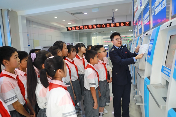 In the tax service hall of Changshou District, the students are listening carefully to the tax officials explaining the operation steps of invoice generation and the related knowledge of invoice. Photo by Yuan Hongyu