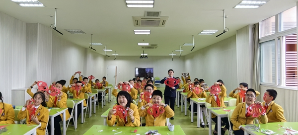 At Ditao School in Dazu District, tax officials and classmates took a group photo with the paper-cut "Tax Emblem" as a souvenir. Meng xiangfei