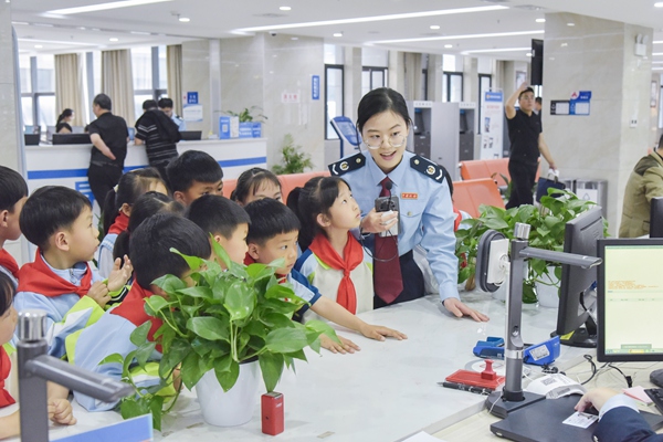 In the Tax Service Hall of fengjie county, the tax staff led the "Little Tax Experiencer" to visit the tax window, and guided the students to experience the tax service in an immersive way. Photo by Cai Zhongyu